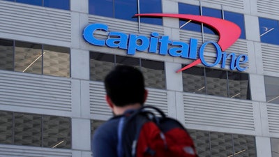 In this July 16, 2019, file photo, a man walks across the street from a Capital One location in San Francisco. A security breach at Capital One Financial, one of the nation's largest issuers of credit cards, compromised the personal information of about 106 million people, and in some cases the hacker obtained Social Security and bank account numbers.