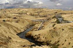 In this May 10, 2019 photo provided by the California Department of Fish and Wildlife's Office of Spill Prevention and Response, oil flows at a Chevron oil field in Kern County, Calif. Nearly 800,000 gallons of oil and water has seeped from the ground since May. Chevron and California officials say the spill is not near any waterway and has not significantly affected wildlife.