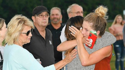 Aryn Fonda, right, hugs, Jade Oar, who was friends with Delaney Wykle during a prayer vigil that was held for the victims of the helicopter accident Thursday, July 11, 2019 at the Paul Cline Memorial Sports Complex in Beckley, W.Va. Chris Cline, his daughter Kameron Cline, Beckley native Delaney Wykle and four others were killed last week when their helicopter crashed after taking off from a remote private island in the Bahamas.