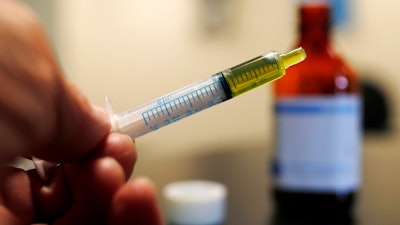In this Nov. 6, 2017 file photo, a syringe with a dose of CBD oil is shown in a research laboratory in Fort Collins, Colo. CBD is a compound found in marijuana but doesn’t cause a high. On Tuesday, July 23, 2019, the Food and Drug Administration announced it has warned Curaleaf Inc., of Wakefield, Mass., for illegally selling unapproved CBD products. The agency says Curaleaf’s claims could lead people to delay medical care for serious conditions like cancer.