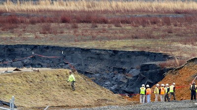 In a Wednesday, Feb. 5, 2014 file photo, Duke Energy engineers and contractors survey the site of a coal ash spill at the Dan River Power Plant in Eden, N.C. The federal, North Carolina and Virginia governments want a judge to declare Charlotte-based Duke Energy liable for environmental damage from a leak five years ago that left miles of a river shared by the two states coated in hazardous coal ash. Government lawyers on Thursday, July 18, 2019 sought to have Duke Energy declared responsible for harming fish, birds, amphibians and the bottom of the Dan River.