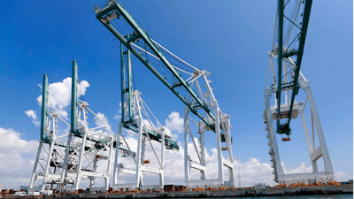 In this Wednesday, July 24, 2019 photo, large cranes to unload container ships are shown at PortMiami in Miami. According to the National Association for Business Economics quarterly survey, released Monday, July 29, U.S. business economists expect economic growth to slow this year, and a rising proportion of them think corporate sales and profits will decline.