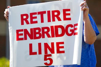 In this 2017 file photo, a protester stands in opposition to the decades-old Enbridge Line 5.