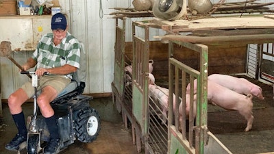 In this July 10, 2019, photo, farmer Mark Hosier, 58, rides a scooter as he checks on his pigs on his farm in Alexandria, Ind. Hosier was injured in 2006, when a 2000-pound bale of hay fell on him while he was working. Assistive technology, help from seasonal hires and family members, and a general improvement in the health of U.S. seniors in recent decades have helped farmers remain productive and stay on the job well into their 60s, 70s and beyond.