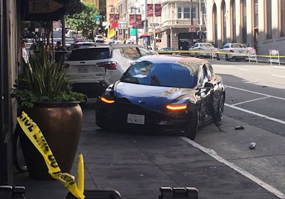 In this Sunday, July 21, 2019 file photo shows the scene after a woman was arrested after running a red light in a rented Tesla in San Francisco and causing a crash that killed a tourist and left his wife critically injured. San Francisco police said Wednesday, July 24, 2019, preliminary information shows a rented Tesla that was speeding when it ran a red light and struck a couple was not on semi-autonomous Autopilot mode.