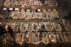 This Nov. 15, 2018, aerial file photo shows the remains of residences leveled by the Camp wildfire in Paradise, Calif. A group of insurance companies are offering a plan to take over Pacific Gas & Electric, the latest to offer competing proposals to pay the utility's wildfire liabilities and pull it out of bankruptcy. In court filings Tuesday, July 23, 2019, the insurers said PG&E Corp. owes them more than $20 billion in claims paid to victims of recent California wildfires caused by PG&E equipment and offered a 'viable path' to emerge from bankruptcy.