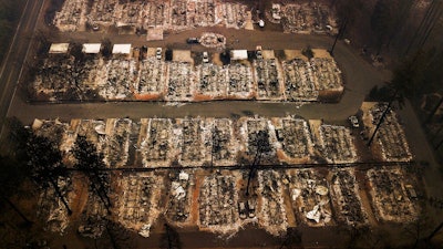 This Nov. 15, 2018, aerial file photo shows the remains of residences leveled by the Camp wildfire in Paradise, Calif. A group of insurance companies are offering a plan to take over Pacific Gas & Electric, the latest to offer competing proposals to pay the utility's wildfire liabilities and pull it out of bankruptcy. In court filings Tuesday, July 23, 2019, the insurers said PG&E Corp. owes them more than $20 billion in claims paid to victims of recent California wildfires caused by PG&E equipment and offered a 'viable path' to emerge from bankruptcy.