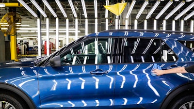 In this June 24, 2019, file photo a Ford employee works on a Ford Explorer line at Ford's Chicago Assembly Plant in Chicago's Hegewisch neighborhood. Ford Motor Co. reports earning on Wednesday, July 24, 2019.