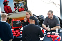 Recruiters talk to prospective workers at a job fair.