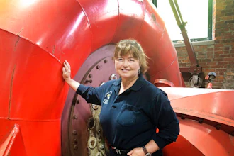 In this June 5, 2019 photo, Natural Power Group co-owner Sarah Bower-Terbush stands in front of a power turbine at the company's hydroelectric site in Wappingers Falls, N.Y. She and her husband sell renewable power to local customers from three hydroelectric sites they operate in the Hudson Valley. Customers say they like investing their money locally in clean power.