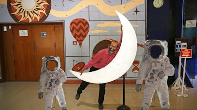An employee playfully hugs a cut-out of a crescent moon at the Nehru Planetarium in New Delhi, India, Thursday, July 11, 2019. India is looking to take a giant leap in its space program and solidify its place among the world’s spacefaring nations with its second unmanned mission to the moon, this one aimed at landing a rover near the unexplored south pole.