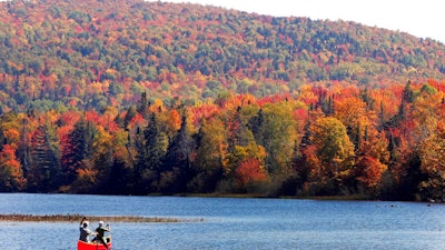 In this Sept. 27, 2014 file photo, Brad and Sue Wyman paddle their 1930's Old Town Guide canoe along the Androscoggin River as leaves display their fall colors north of the White Mountains in Dummer, N.H. The New Hampshire Supreme Court on Friday, July 19, 2019 upheld a state committee's rejection of a proposal to bring a hydropower transmission line from Canada to markets in southern New England, possibly dealing a fatal blow to a plan that has raised concerns among communities and environmentalists that it would harm the region's tourism industry and hurt property values.