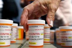 In this Aug. 17, 2018, file photo, family and friends who have lost loved ones to OxyContin and opioid overdoses leave pill bottles in protest outside the headquarters of Purdue Pharma, which is owned by the Sackler family, in Stamford, Conn. New York is suing the billionaire family behind Oxycontin, alleging the drugmaker fueled the opioid crisis by putting hunger for profits over patient safety.