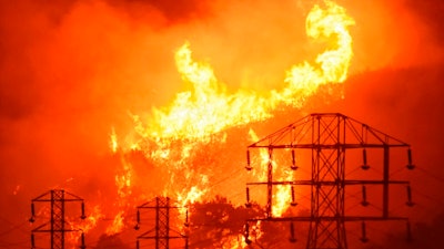 In this Dec. 16, 2017, file photo provided by the Santa Barbara County Fire Department, flames burn near power lines in Sycamore Canyon near West Mountain Drive in Montecito, Calif. A Wednesday, July 10, 2019, report in the Wall Street Journal says Pacific Gas & Electric, which is blamed for some of California's deadliest recent fires, knew for years that dozens of its aging power lines posed a wildfire threat but avoided replacing or repairing them. PG&E says it disagrees with the Journal's conclusions but says it’s 'taking significant actions to inspect, identify, and fix' safety issues.