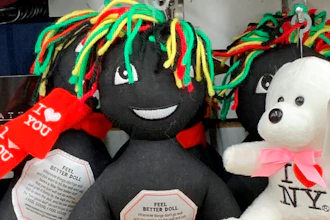 This undated photo provided by New Jersey state Assemblywoman Angela McKnight shows three 'Feel Better Dolls' sharing the shelf with a stuffed animal bearing an 'I Love New York' message at a One Dollar Zone store in Bayonne, N.J. The black rag 'Feel Better' dolls that came with instructions to 'find a wall' and slam the toy against it have been pulled from three stores after customers and the lawmaker said they were offensive.