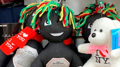 This undated photo provided by New Jersey state Assemblywoman Angela McKnight shows three 'Feel Better Dolls' sharing the shelf with a stuffed animal bearing an 'I Love New York' message at a One Dollar Zone store in Bayonne, N.J. The black rag 'Feel Better' dolls that came with instructions to 'find a wall' and slam the toy against it have been pulled from three stores after customers and the lawmaker said they were offensive.