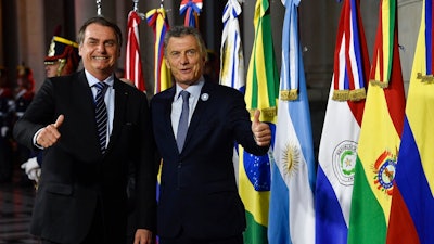 Argentina's President Mauricio Macri, right, gives a thumbs up to photographers with Brazil's President Jair Bolsonaro during a photo opportunity at the Mercosur Summit in Santa Fe, Argentina, Wednesday, July 17, 2019. The South American trading bloc that includes founding members Brazil, Argentina, Paraguay, and Uruguay, is one of the world's largest.
