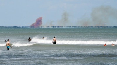In this April 20, 2019, file photo, cloud of orange smoke rises over nearby Cape Canaveral Air Force Station, as seen from Cocoa Beach, Fla., after the SpaceX Dragon 2 capsule was destroyed during a test. SpaceX says a leaky valve caused its crew capsule to explode during the test back in April. The company announced the preliminary results of its accident investigation Monday, July 15, 2019.