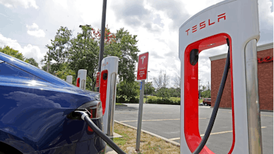 In this July 19, 2019, photo a Tesla vehicle charges at a Tesla Supercharger site in Charlotte, N.C. Tesla, Inc. reports earning on Wednesday, July 24, 2019.
