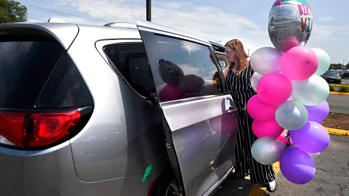 In this Tuesday, July 16, 2019, Melanie Matcheson loads balloons into her Chrysler Pacifica in Southington, Conn. For Melanie Matcheson, no vehicle other than a minivan could efficiently haul her family of two adults and five children ages 2 to 22.