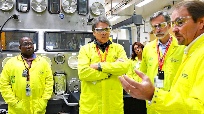 In this May 10, 2017, file photo provided by the Los Alamos National Laboratory, U.S. Secretary of Energy Rick Perry, second from left, accompanied by Laboratory Director Charlie McMillan, second from right, learns about capabilities at the Los Alamos Laboratory Plutonium Facility, from Jeff Yarbrough, right, Los Alamos Associate Director for Plutonium Science and Manufacturing, in Los Alamos.