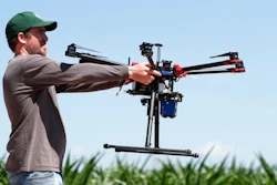 In this Thursday, July 11, 2019, photograph, United States Department of Agriculture intern Alex Olsen prepares to place down a drone at a research farm northeast of Greeley, Colo. Researchers are using drones carrying imaging cameras over the fields in conjunction with stationary sensors connected to the internet to chart the growth of crops in an effort to integrate new technology into the age-old skill of farming.
