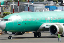 In this May 8, 2019, file photo a worker stands near a Boeing 737 MAX 8 jetliner being built for American Airlines prior to a test flight in Renton, Wash. Boeing is working on new software for the 737 Max that will use a second flight control computer to make the system more reliable, solving a problem that surfaced in June with the grounded jet, two people briefed on the matter said Friday, Aug. 2.