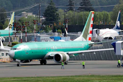 In this Wednesday, May 8, 2019 file photo, workers stand near a Boeing 737 MAX 8 jetliner being built for American Airlines prior to a test flight in Renton, Wash. Federal safety officials are recruiting pilots from airlines around the world to test changes that Boeing is making in flight-control software on the grounded 737 Max jet, according to two people briefed on the situation