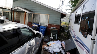 Vehicles are parked outside the home of Paige A. Thompson, who uses the online handle 'erratic,' Wednesday, July 31, 2019, in Seattle. Thompson was taken into custody Monday at her home and has been charged with computer fraud and abuse in connection with hacking data from more than 100 million Capital One credit holders or applicants.