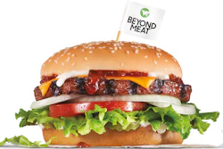 Photo shows a Carl's Jr. Beyond Famous Star Burger. It features the Beyond Burger patty topped with melted American cheese, lettuce, tomato, sliced onions, dill pickles, special sauce and mayonnaise on a seeded bun.
