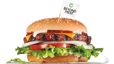 Photo shows a Carl's Jr. Beyond Famous Star Burger. It features the Beyond Burger patty topped with melted American cheese, lettuce, tomato, sliced onions, dill pickles, special sauce and mayonnaise on a seeded bun.