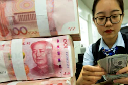 A banker in China counts American currency.