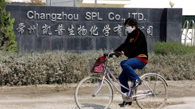 In this Thursday, March 14, 2008 file photo, a woman rides a bicycle past Changzhou SPL in Changzhou, China. The FDA did not open its first permanent offices in China and India until 2008 and 2009, respectively. That followed dozens of deaths and hundreds of allergic reactions in the U.S. linked to the contaminated blood thinner heparin made at this Chinese facility.