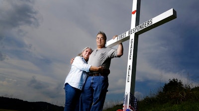 In this Aug. 6, 2019, photo, Ansol and Janie Clark pose at a memorial Ansol Clark constructed near the Kingston Fossil Plant in Kingston, Tenn. The Tennessee Valley Authority was responsible for a massive coal ash spill at the plant in 2008 that covered a community and fouled rivers. The couple says the memorial is for the workers who have come down with illnesses, some fatal, including cancers of the lung, brain, blood and skin and chronic obstructive pulmonary disease. Ansol Clark drove a fuel truck for four years at the cleanup site, and now suffers from a rare blood cancer.