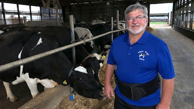 Dave Daniels stands in front of some of his 575 dairy cows on his farm in Union Grove, Wisconsin. He voted for President Donald Trump, and says he's frustrated to be a political pawn in the trade war.