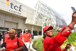 Gina Peoples, right, of Detroit, a volunteer with The Parade Company, takes a selfie in front of the newly named TCF Center in downtown Detroit Tuesday, Aug. 27, 2019. Politicians, executives and VIPs gathered at what had been known as Cobo Center since 1960 for the renaming announcement.