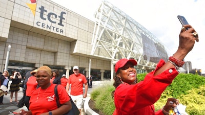 Gina Peoples, right, of Detroit, a volunteer with The Parade Company, takes a selfie in front of the newly named TCF Center in downtown Detroit Tuesday, Aug. 27, 2019. Politicians, executives and VIPs gathered at what had been known as Cobo Center since 1960 for the renaming announcement.