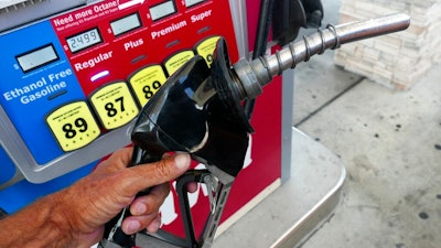 In this June 26, 2019, file photo, a man adds fuel to his vehicle at a gas station in Orlando, Fla. A coalition of states is suing the Trump administration for the second time to block a planned reduction in penalties automakers pay when they fail to meet fuel economy standards. Twelve states and the District of Columbia sued the administration Friday, Aug. 2, 2019, for replacing an Obama-era regulation that imposed a penalty of $14 for every tenth of a mile-per-gallon that an automaker falls below the standards.