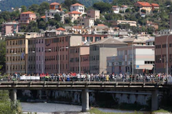 People that did not take part in the ceremony to mark the first anniversary of the Morandi bridge collapse, stage their own commemoration on the bridge on the Polcevera river in Genoa, Italy, Wednesday, Aug. 14, 2019. The Morandi bridge was a road viaduct on the A10 motorway in Genoa, that collapsed one year ago killing 43 people.
