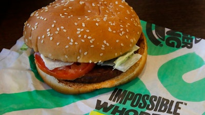 In this Wednesday, July 31, 2019 photo, an Impossible Whopper burger is photographed at a Burger King restaurant in Alameda, Calif. Burger King will soon offer its Impossible Whopper plant-based burger nationwide. The chain said the soy-based burger, made by Impossible Foods, will be available for a limited time at its 7,000 U.S. stores starting next week.