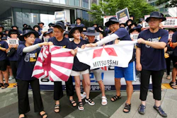 South Korean college students tear banners showing an image of a Japanese rising sun flag and the logo of Mitsubishi Corp. during a rally to denounce Japan's new trade restrictions on South Korea in front of the office of Mitsubishi Corp. in Seoul, South Korea, Wednesday, Aug. 7, 2019. Japanese Prime Minister Shinzo Abe said Tuesday that the main cause of escalating tensions between Japan and South Korea is a loss of trust over court rulings ordering Japanese companies to compensate South Koreans for forced labor during World War II.