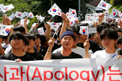 South Korean middle school students wave the national flags during a rally against Japan in Seoul, South Korea, Wednesday, Aug. 28, 2019. Japan's downgrading of South Korea's trade status took effect Wednesday, a decision that has already set off a series of reactions hurting bilateral relations.