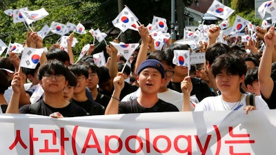 South Korean middle school students wave the national flags during a rally against Japan in Seoul, South Korea, Wednesday, Aug. 28, 2019. Japan's downgrading of South Korea's trade status took effect Wednesday, a decision that has already set off a series of reactions hurting bilateral relations.