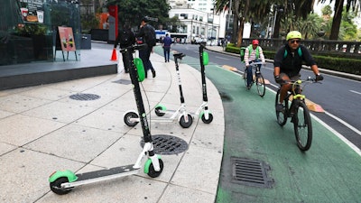 Scooters are left after being used on the sidewalk on Reforma Avenue in Mexico City, Thursday, Aug. 1, 2019. An electric scooter firm has temporarily ceased operations in Mexico City because so many of its two-wheeled units have been stolen. The Grin company said in a statement that 'at present, the theft of our scooters in Mexico City is the biggest challenge.'