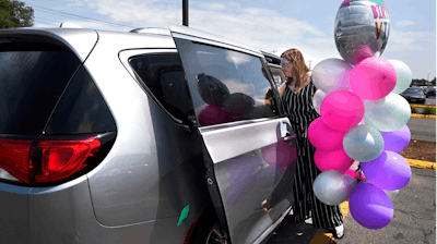 In this Tuesday, July 16, 2019, Melanie Matcheson loads balloons into her Chrysler Pacifica in Southington, Conn. For Melanie Matcheson, no vehicle other than a minivan could efficiently haul her family of two adults and five children ages 2 to 22.