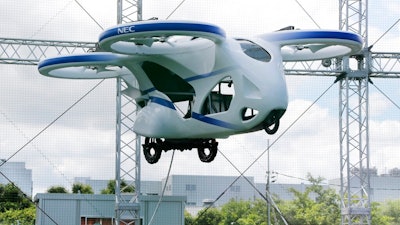 NEC Corp.'s machine with propellers hovers at the company's facility in Abiko near Tokyo, Monday, Aug. 5, 2019. The Japanese electronics maker showed a 'flying car,' a large drone-like machine with four propellers that hovered steadily for about a minute.