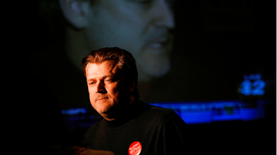 In this Nov. 6, 2007, file photo Patrick Byrne, President and CEO of Overstock.com is reflected on a large television screen while being interviewed at the headquarters for supporters of school vouchers in Salt Lake City.