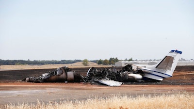 The burned out remains of a twin-engine Cessna Citation sits at the end of a runway after the pilot aborted the takeoff at the Oroville Airport in Oroville, Calif., Wednesday, Aug. 21, 2019. The plane carried two pilots and eight passengers, who all escaped injury. Firefighters were able to quickly control a grass fire that broke out and temporarily closed Highway 162. No cause of the crash has been listed.