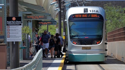 A light rail train stops for passengers, Monday, Aug. 26, 2019 in Tempe, Ariz. The latest numbers on mail-in ballots are expected Monday after the weekend for Tuesday's special election weighing any future expansion to the light rail system in Phoenix, the nation's fifth largest city.
