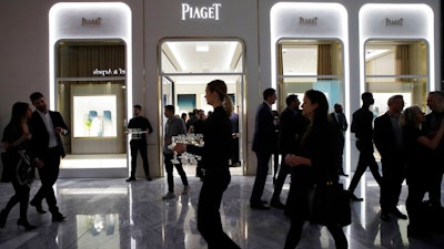 In this March 14, 2019, file photo people attend the opening of a Piaget store during the opening night of The Shops & Restaurants at Hudson Yards in New York. The U.S. job market isn’t quite as strong as originally believed, with revised figures showing that the economy had 501,000 fewer total jobs this March than initially reported. The Labor Department says that nearly two-thirds of the downward revision came from the retail and leisure and hospitality sectors, the industries most associated with consumer spending.